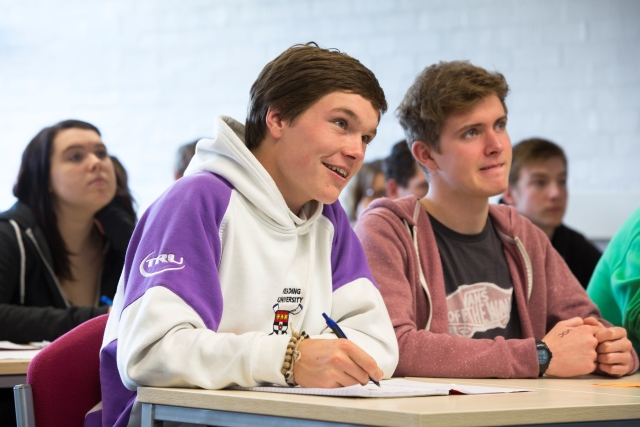 Students listening intently, at desks in classrooom