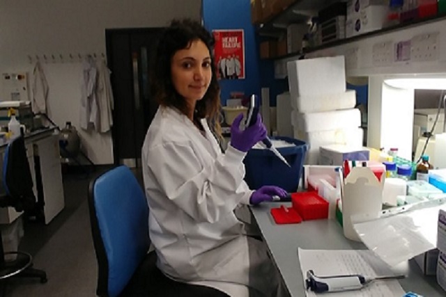 Pharmacist sitting at a lab table 
