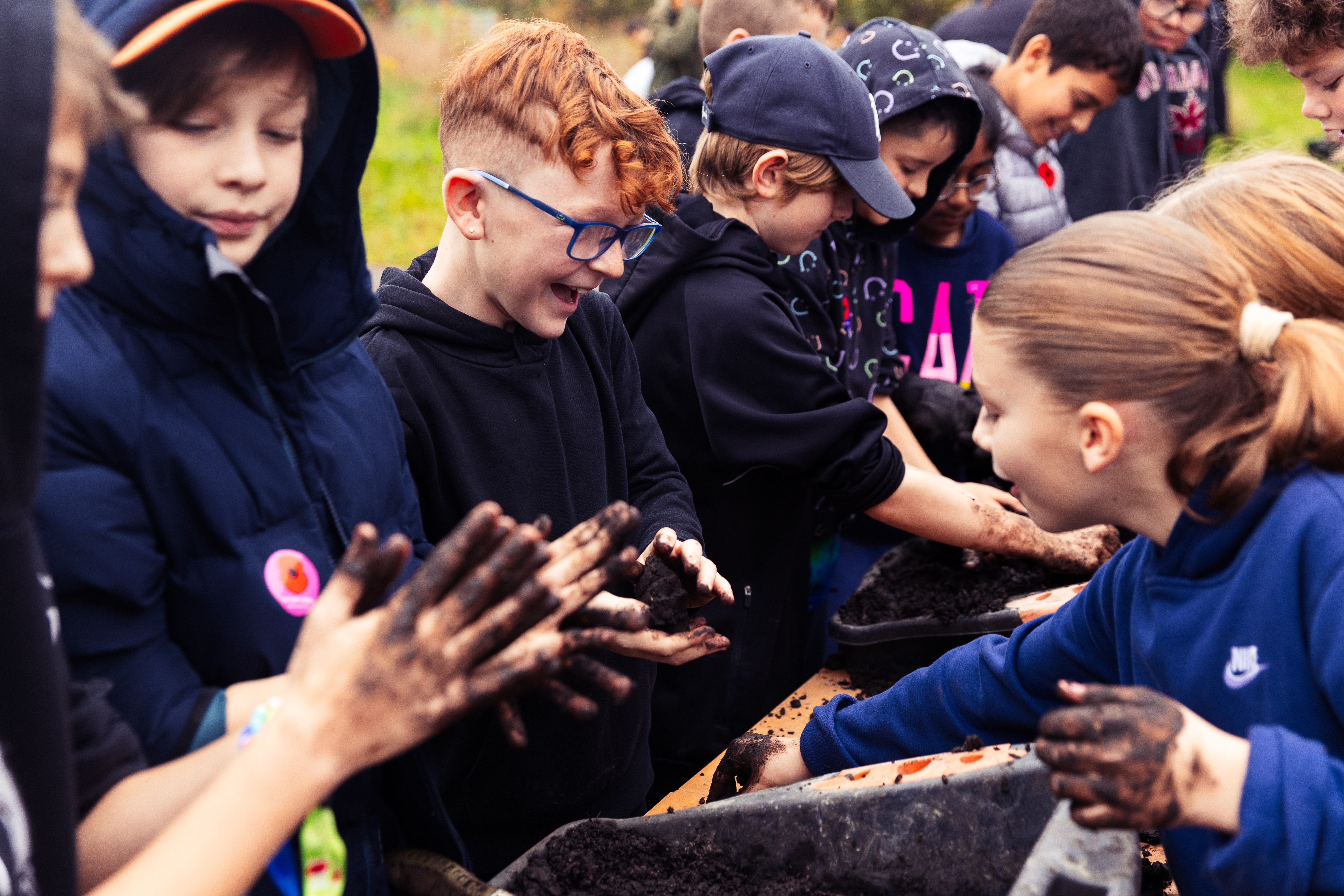 A group of school children taking part in a muddy activity