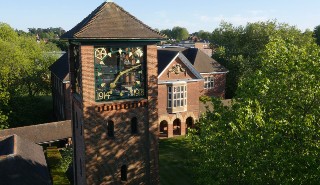 The clock tower on London Road campus with buildings and grounds in the background