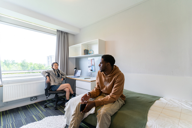 Students sat talking in bedroom