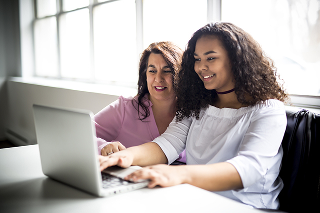 Two women working at a laptop