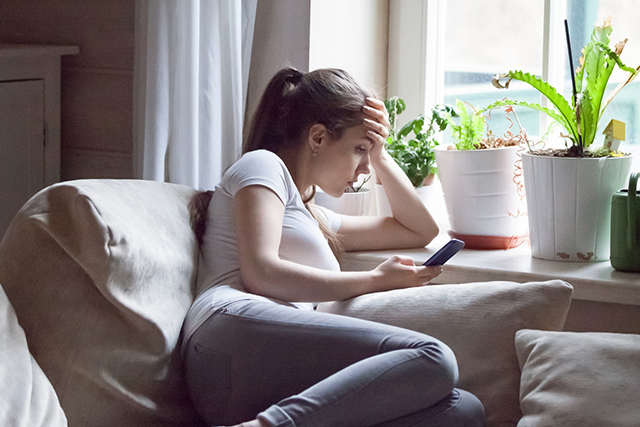 Image of a young woman looking into her phone
