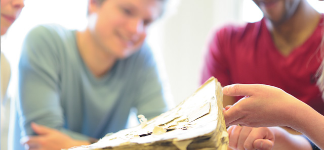 Students examining ancient book